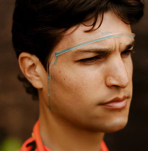 A man wearing a Veo Strip with blue liquid being diverted from his forehead to the side of his face